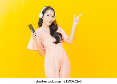 Portrait Beautiful Young Asian Woman With Headphone And Smart Phone For Listen Music On Yellow Background