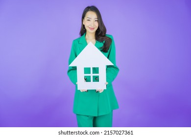 Portrait beautiful young asian woman with house or home paper sign on color background - Shutterstock ID 2157027361