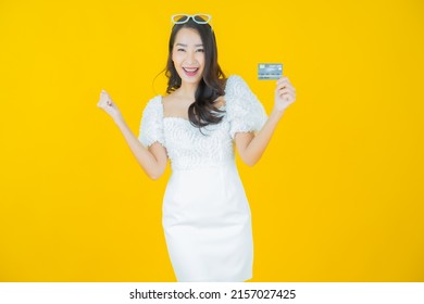Portrait beautiful young asian woman smile with credit card on color background - Shutterstock ID 2157027425
