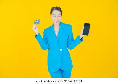 Portrait beautiful young asian woman smile with credit card on color background - Shutterstock ID 2157027431