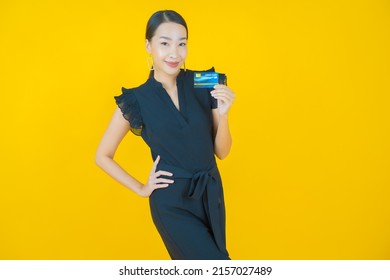 Portrait beautiful young asian woman smile with credit card on color background - Shutterstock ID 2157027489