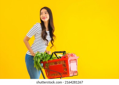 Portrait Beautiful Young Asian Woman Shopping Grocery From Supermarket And Cart On Yellow Isolated Background