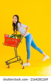 Portrait beautiful young asian woman shopping grocery from supermarket and cart on yellow isolated background - Shutterstock ID 2164281269