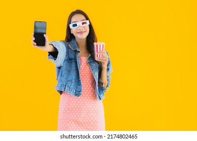Portrait Beautiful Young Asian Woman Enjoy Happy With Phone Popcorn And Watch Movie On Yellow Isolated Background