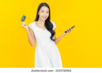 Portrait beautiful young asian woman smile with credit card on yellow color background - Shutterstock ID 2193720963