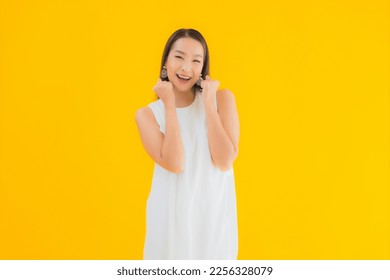 Portrait beautiful young asian woman in action on yellow isolated background - Shutterstock ID 2256328079