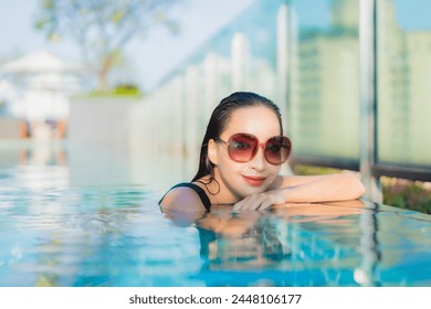 Portrait beautiful young asian woman relax smile around outdoor swimming pool in hotel resort - Powered by Shutterstock