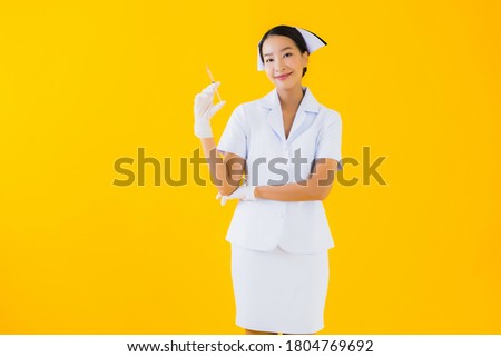 Portrait beautiful young asian woman thai nurse wear glove on yellow isolated background