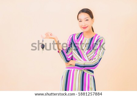 Portrait beautiful young asian woman show car key on color background