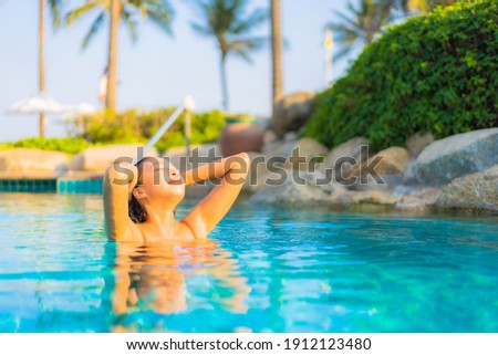 Portrait beautiful young asian woman relax smile leisure around outdoor swimming pool with sea ocean view
