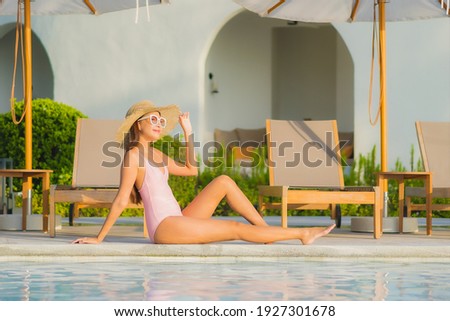 Portrait beautiful young asian woman relax leisure around outdoor swimming pool with sea beach ocean view in vacation travel