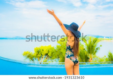 Portrait beautiful young asian woman relax smile leisure around outdoor swimming pool with sea ocean view for travel vacation