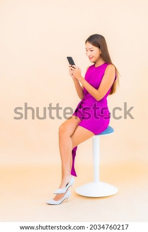Portrait beautiful young asian woman use smart mobile phone on color background