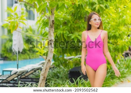 Portrait beautiful young asian woman relax smile around outdoor swimming pool in hotel resort for travel vacation