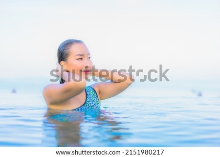 Portrait beautiful young asian woman relax smile leisure around outdoor swimming pool nearly sea beach in Travel vacation