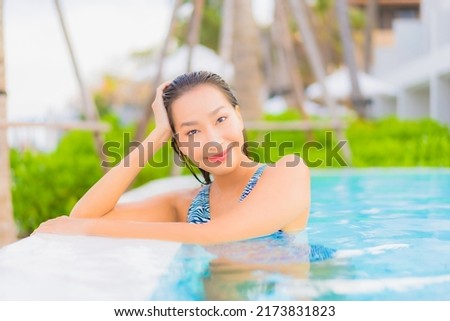 Portrait beautiful young asian woman relax leisure around outdoor swimming pool with sea ocean beach