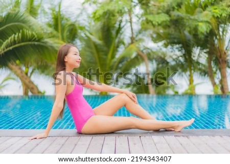 Portrait beautiful young asian woman smile relax around outdoor swimming pool in resort hotel on holiday vacation travel trip