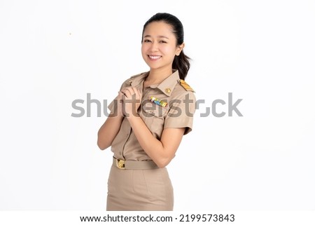 Portrait of beautiful young Asian woman standing and smiling isolated on white background, looking at camera, woman in cream Thai government uniform.