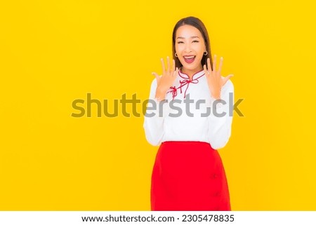 Portrait beautiful young asian woman smile in action on yellow background