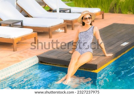 Portrait beautiful young asian woman relax smile enjoy leisure around swimming pool in resort hotel on vacation