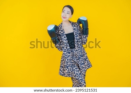 Portrait beautiful young asian woman with boxing glove on color background