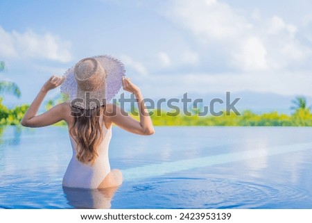 Portrait beautiful young asian woman enjoy around outdoor swimming pool with sea ocean view in travel vacation trip