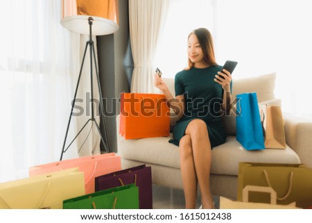 Portrait beautiful young asian women sitting on sofa chair using computer laptop or smart and mobile phone with credit card for online shopping