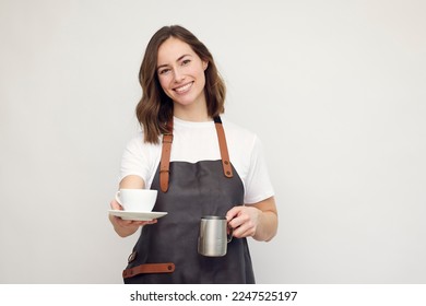 portrait of beautiful young barista woman serving coffee with a big smile	