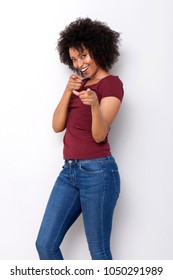 Portrait of beautiful young black woman smiling and pointing fingers on white background