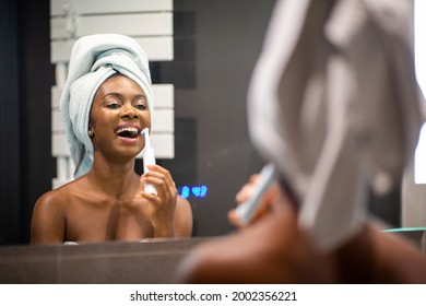 Portrait Beautiful Young Black Woman Smiling And Brushing Teeth In Bathroom