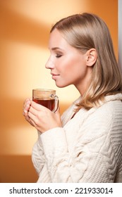 Portrait of a beautiful young blond holding cup of warm tea.