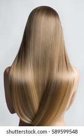 Portrait Of A Beautiful Young Blond Woman With Long Straight Hair. Back View.