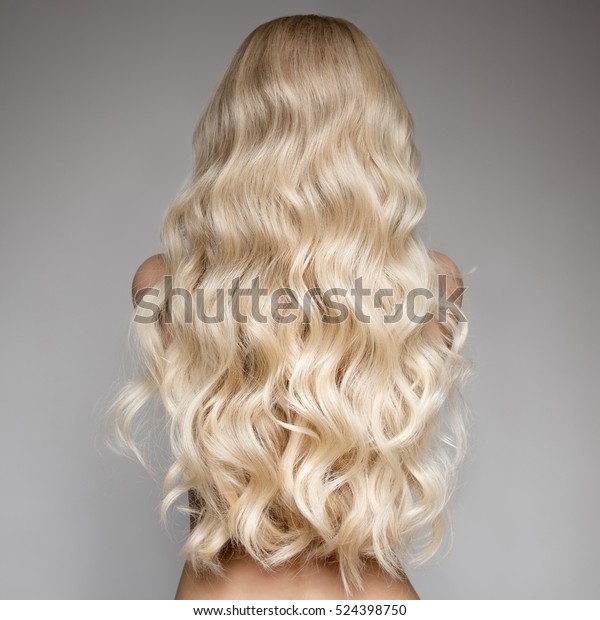 Portrait Of Beautiful Young Blond Woman With Long\
Wavy Hair. Back View