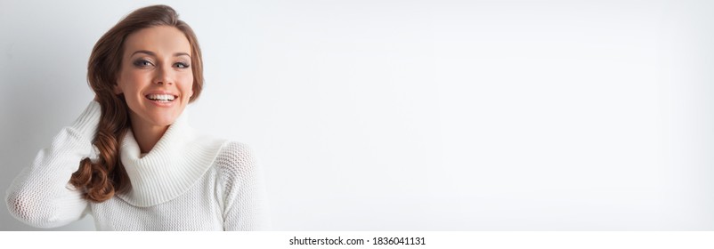 Porträt einer schönen jungen blonden Kaukasierin mit flacher Haut und perfektem Make-up im Winter weißer Pullover