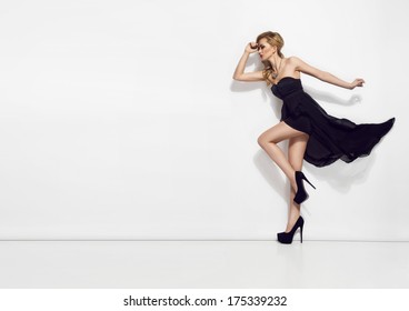 Portrait Of Beautiful Young Blonde Girl In Black Dress. Fashion Photo 