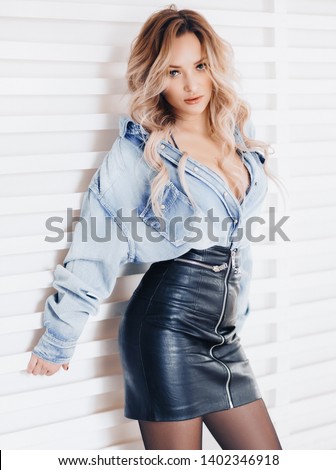 Portrait of beautiful young blonde woman with makeup in bright blue fashion clothes