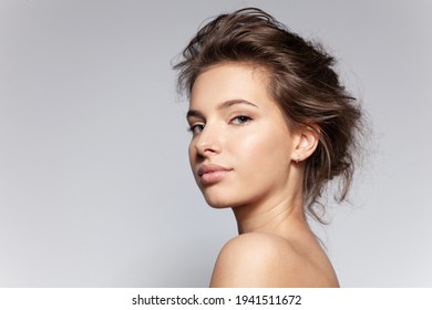 Portrait Of Beautiful Young Caucasian Female With Bare Shoulder On Gray Background With Copyspace For Ad. Pretty Millennial Girl Model With Clean Healthy Moisturized Skin. Natural Beauty Concept