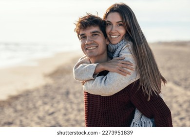 Portrait of beautiful young couple in love enjoying the day in a cold winter on the beach. - Powered by Shutterstock