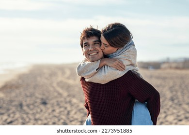 Portrait of beautiful young couple in love enjoying the day in a cold winter on the beach. - Powered by Shutterstock