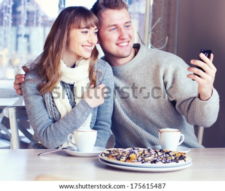 Portrait of Beautiful Young Couple in Love, couple having fun talking in cafe and drink coffee. Concept of relationship, love story, preparations for wedding, fashionable clothing