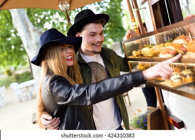 Portrait Of Beautiful Young Couple Visiting Eat Market In The Street.