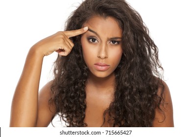 Portrait Of A Beautiful Young Dark-skinned Woman, Lift Her Eyebrow With Her Finger On A White Background