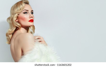 Portrait of a beautiful young girl with blond wavy hair and with red lips and black arrows in retro style.Portrait of a beautiful young girl with blond wavy hair and with red lips and black arrows in 