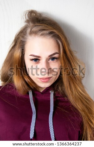 portrait of a beautiful young girl with blue eyes and blond almost red hair