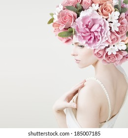 花を持つ美しい若い女の子のポートレート。牡丹とバラの接写。スタジオショット。