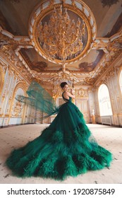 Portrait Of A Beautiful Young Girl In A Haute Couture Green Dress Standing In A Luxurious Gold Interior.