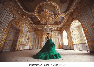 Portrait Of A Beautiful Young Girl In A Haute Couture Green Dress Standing In A Luxurious Palace Interior.