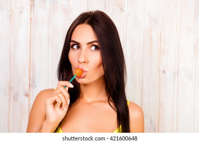 Portrait of beautiful young girl licking chupa chups