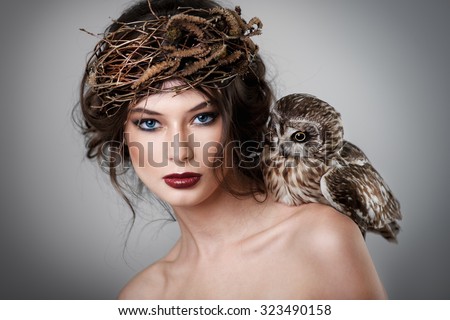 Portrait of beautiful young girl with owl 