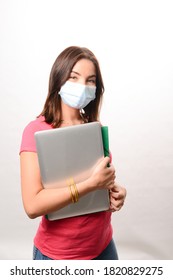 Portrait Of Beautiful Young Girl Student Isolated On White Background Wearing A Covid 19 Surgical Mask Protection